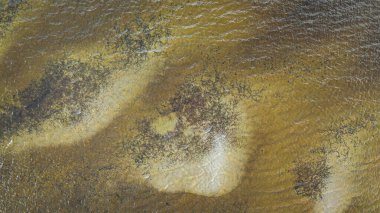 Nehir yüzeyinin yüksek irtifasından gökyüzü görüntüsü. Su dokusunun arka planı. Güneşli bir günde kuş bakışı dalgalı su manzarası.