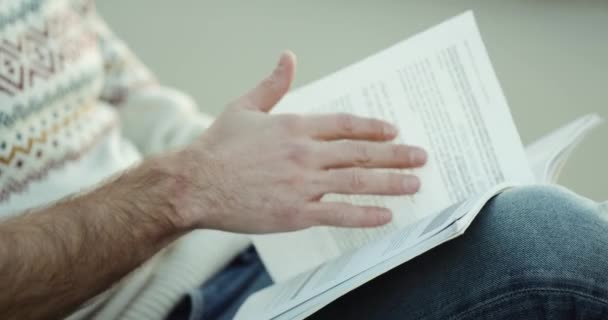 Um homem está sentado e lendo um livro 4k. HD — Vídeo de Stock