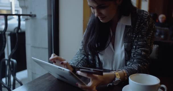 Giovane donna che fa shopping online su tablet computer in caffè. Ragazza felice . — Video Stock