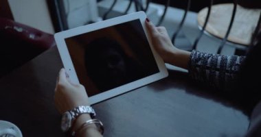 Holding Tablet Pc manzara modunda açık kahve dükkanı kızdır. Kırmızı sinema kamera 4 k atış