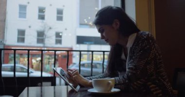Tablet bilgisayar kafede oturan genç kadınla. Ağır çekim. Üzerinde kırmızı sinema kamera çekim