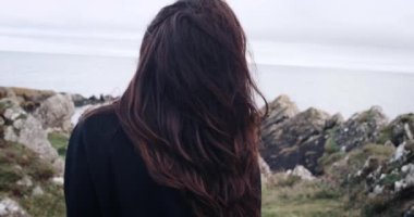 Bir uçurum İrlanda'dan sahile seyir büyülü ve gizemli kız. 4k