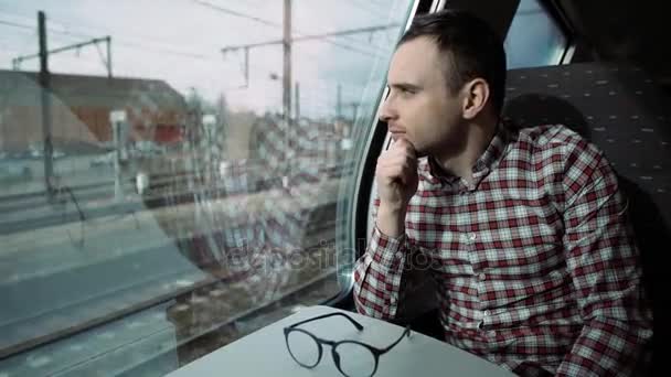 Garçon regardant par la fenêtre du train dehors, le soir, voyage. 4K — Video