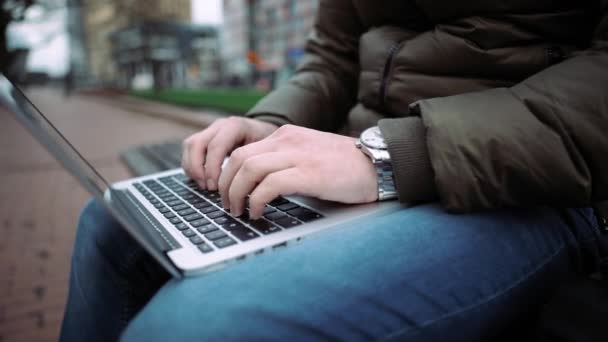 Visão superior mãos masculinas usando notebook ao ar livre em ambiente urbano enquanto digita no teclado. .4k — Vídeo de Stock