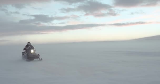 Un viaggiatore vestito con abiti tradizionali Yamal alla guida di una motoslitta in bufera artica. 4k epico rosso. Lento motion.hd — Video Stock