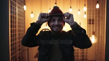 Karizmatik çocuk şapka onun kafa, gece, ışıklar ile arka plan ile oynarken. Neşeli çocuk. 4 k. çocuk gülümseme.