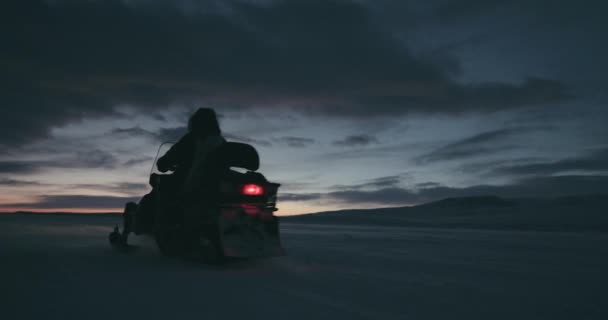 在通过对美丽的日落大场暴雪驯鹿皮大衣雪地摩托的北极人。2016 年远征。高清 — 图库视频影像