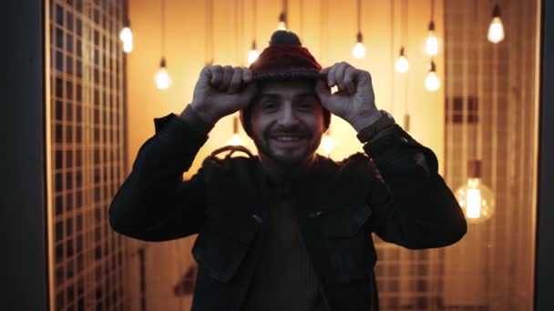 Niño carismático jugando con sombrero en la cabeza, noche, fondo con luces. Muchacho alegre. 4k. Sonrisa infantil . — Vídeos de Stock