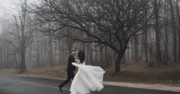 Novia y novio, bailar y jugar con emoción en el camino cerca del bosque, lento. 4k — Vídeos de Stock