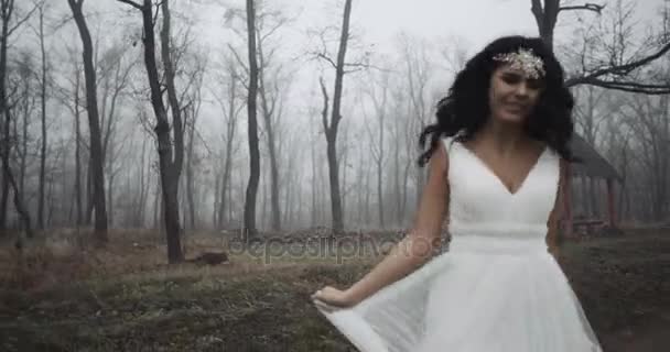 Щаслива наречена проходить через ліс і обертається з красивою посмішкою 4k — стокове відео