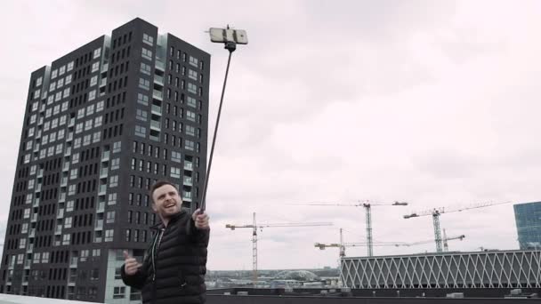 Бородач делает селфи на фоне города. HD — стоковое видео