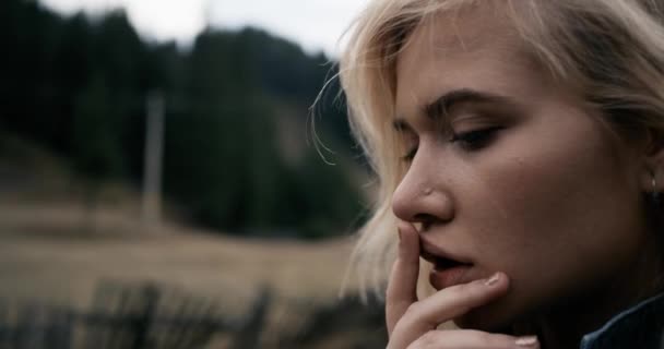 Retrato de una joven hipster y de moda en un sombrero posando al atardecer. Jugando con el dedo en los labios. 4k — Vídeo de stock