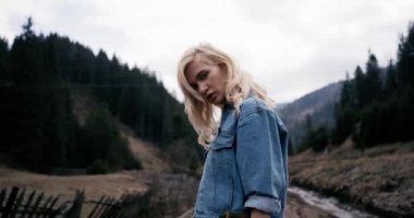 Güzel bir kız, o görünüyor uzakta mesafe içine ve sonra kamera, ciddi dalgın bir görünüm ile profil. 4k