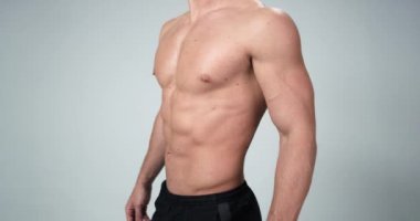 Adam beyaz bir arka plan üzerinde poz kapat, onun kas ve mükemmel vücut göstermektedir. 4k