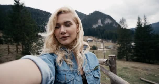 Mulher bonita tomando selfie no campo ao pôr-do-sol. Menina modelo de beleza desfrutando da natureza ao ar livre. Movimento lento . — Vídeo de Stock