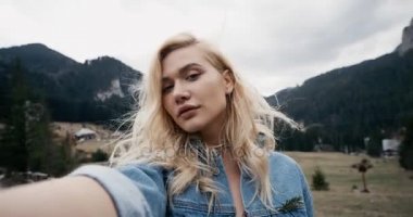 Sarışın kız. Selfie kırsal üzerinde günbatımında alarak güzel ve genç birbayan. Güzellik modeli kız açık havada doğa zevk. Ağır çekim. 4k