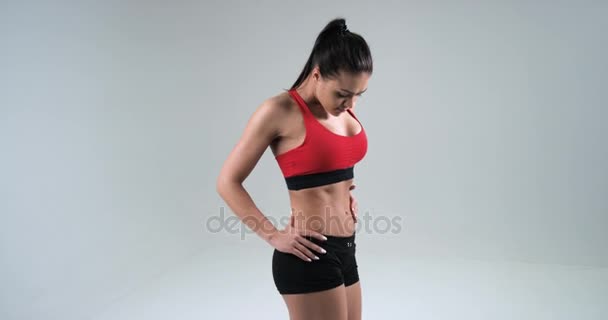 Kroppen av en ung atletisk flicka isolerad på en vit bakgrund. Hälsosam kondition och äta livsstilskoncept. Slow Motion — Stockvideo