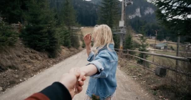 Sigam-me. Jovem mulher atraente carrega sua mão parceiros, levando-o em um pôr do sol . — Vídeo de Stock
