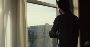 Genç adam BT kenti, ağır çekim pencere arıyorum. 4 o pencerenin, yaklaşımlar sonra döndürür ve yaprakları k..