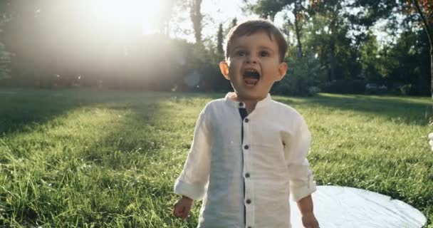 Un petit garçon mignon ressemble à ses yeux devant la caméra. Ralentis. 4k 