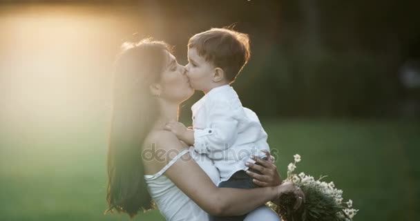 Mamá y su hijo besándose. Precioso primer plano.Madre joven con su pequeño hijo relajándose y jugando en el parque. Ambos son muy felices. 4k — Vídeo de stock