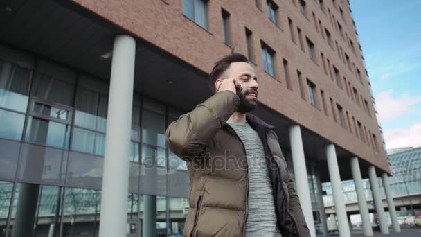 Człowiek, rozmowy na telefon komórkowy na zewnątrz. Brodaty mężczyzna. Człowiek wygląda szczęśliwy — Wideo stockowe