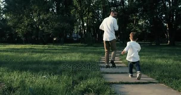 Père avec son fils faisant du jogging dans le parc, au ralenti. 4k . — Video