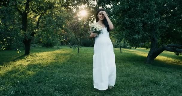 Joven mujer embarazada hermosa con el pelo castaño largo en vestido blanco. 4k. Moción lenta — Vídeos de Stock