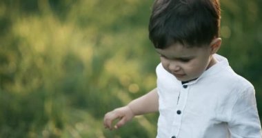 2 yaşındaki çocuk portresi. Parkta yürüyordu. Ağır çekim