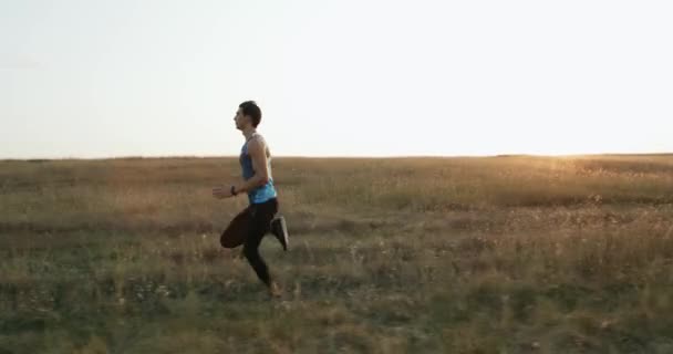 야외에서 운동 하는 슬로우 모션 남자 선수. 스포츠 및 액티브 라이프 스타일입니다. 남성 러너 실루엣, 일몰, 다채로운 일몰 하늘에 실행 하는 남자. — 비디오