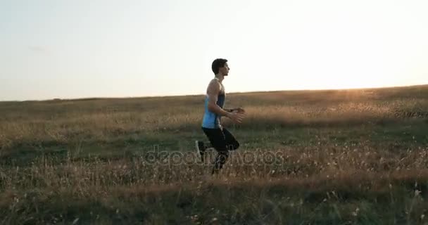 Corredor corredor homem atleta treinando ao ar livre exercitando na estrada da montanha ao pôr do sol na natureza paisagem incrível. Apto bonito atlético masculino exercitando-se para maratona correr fora no verão . — Vídeo de Stock