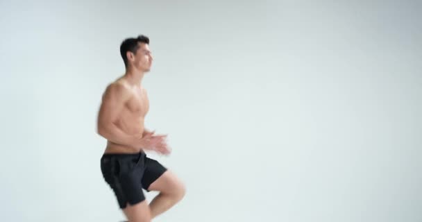 L'uomo muscolare che si scalda sullo sfondo bianco. EPIC ROSSO — Video Stock
