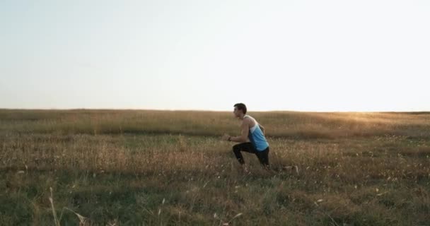 Hombre de fitness haciendo ejercicios de calentamiento. Hombre atleta entrenamiento al aire libre . — Vídeo de stock