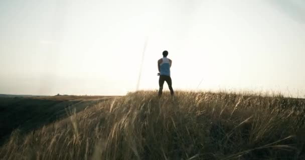 Man doet ochtend oefening. Training staande op de berg achtergrond. Gezonde levensstijl wilskracht motivatie concept. Mannelijke atleet uitoefening van buitenshuis. — Stockvideo