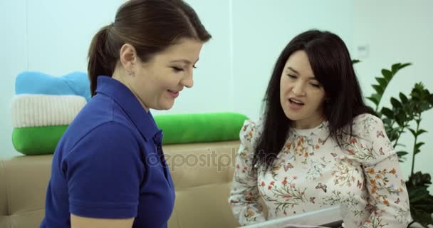 Primer plano médico y su paciente tienen una conversación en el sofá en la sala de espera — Vídeos de Stock