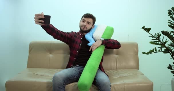 Genç adam kanepede oturan ve selfie bir diş fırçası ile yapma — Stok video