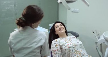 Sabırlı, diş hemşire beklemede dişçi konuştuğu. Hasta gülümsüyor. 4k
