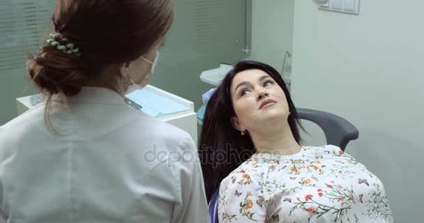 Patiënt op chiar bij tandarts, zitten en de tandheelkundige verpleegkundige de patiënt klaar begin het werk krijgen, tandarts zijn naast — Stockvideo