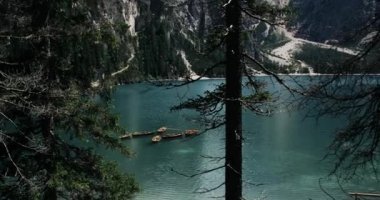 Büyük dağlar ve parlak lake, ahşap tekne yüzen göl kenarında ormanın ortasında. 4k