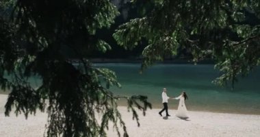 Ormanın ortasında parlak lake ve inanılmaz dağ aşağı yürüme ve onların el ele tutuşarak plaj romantik Çift.