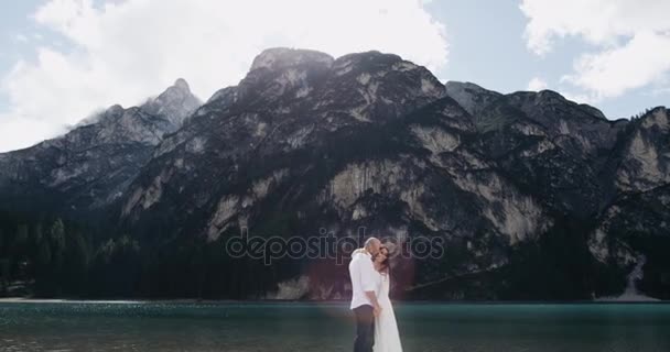 Romantikus pár ölelgeti egymást boldog, háttér egy nagy hegy. lassú mozgás — Stock videók