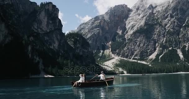 Mladý pár uprostřed jezera na dřevěné lodi relaxační slunečného dne, cestující společně. Zpomalený pohyb — Stock video