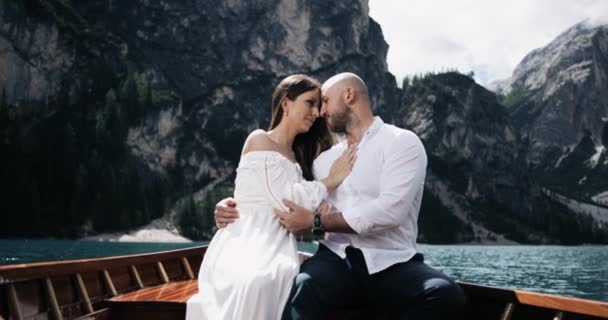 Attractive couple in the wooden boat in the middle of lake playing with each other, man are touching with love and passion his girlfriend. — Stock Video