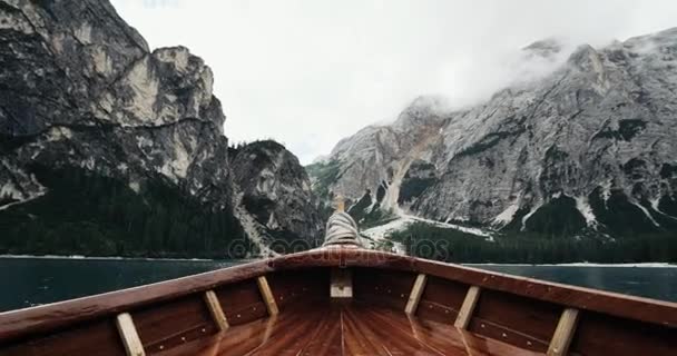 Κινηματογράφηση σε πρώτο πλάνο με ξύλινη βάρκα στη μέση στη λίμνη και φόντο μεγάλα βουνά. 4k — Αρχείο Βίντεο