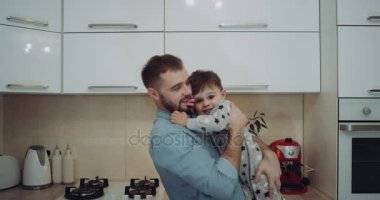 Aşk whit ile onun erkek bebek mutfakta oynarken gülümseyen genç Baba