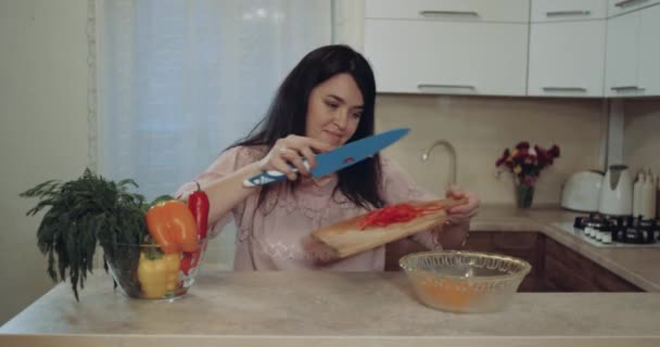 На кухне женщина готовит овощи к ужину — стоковое видео