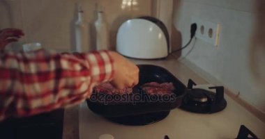 Gaz hob kadına closeup Burger pan dan döner.