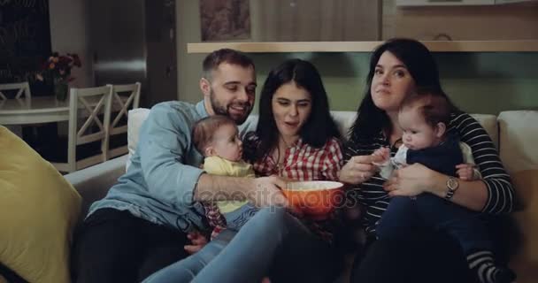 Gelukkig grote familie tv kijken samen met hun baby jongens en de popcorn eten. rode epos — Stockvideo