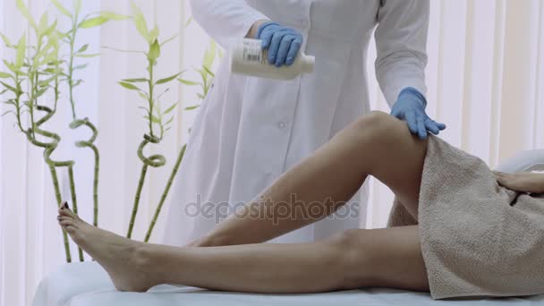 Using foot powder before making the procedure of depilation, beautician get ready to start the waxing process.4k — стоковое видео