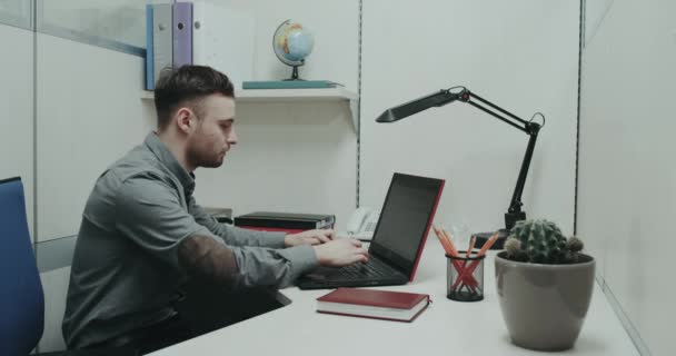 Mężczyzn urząd pracy koncentruje się na jej notebooka, naciskając na klawiaturze. — Wideo stockowe